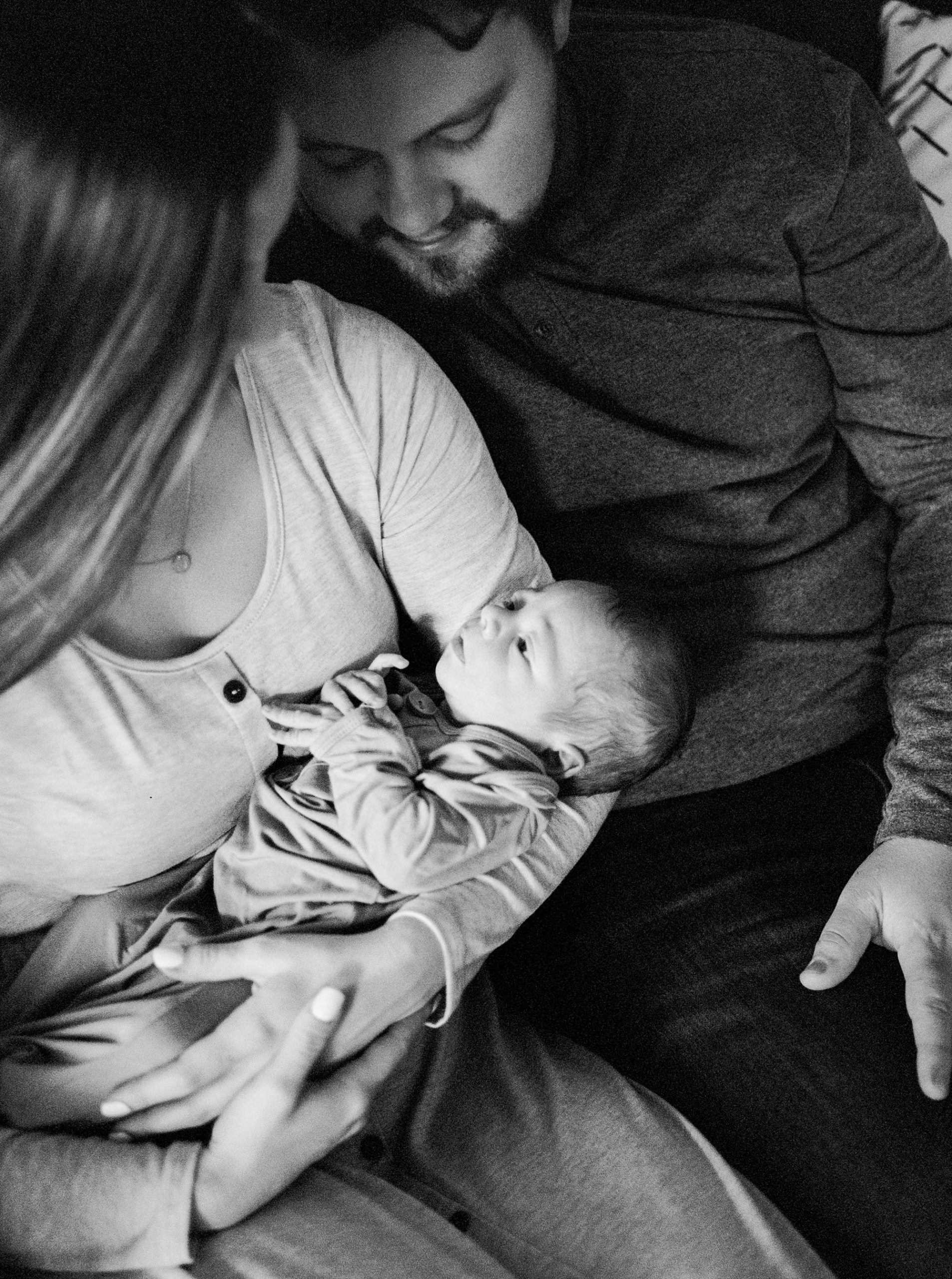 parents look at new baby boy during In Home Lifestyle Newborn photos