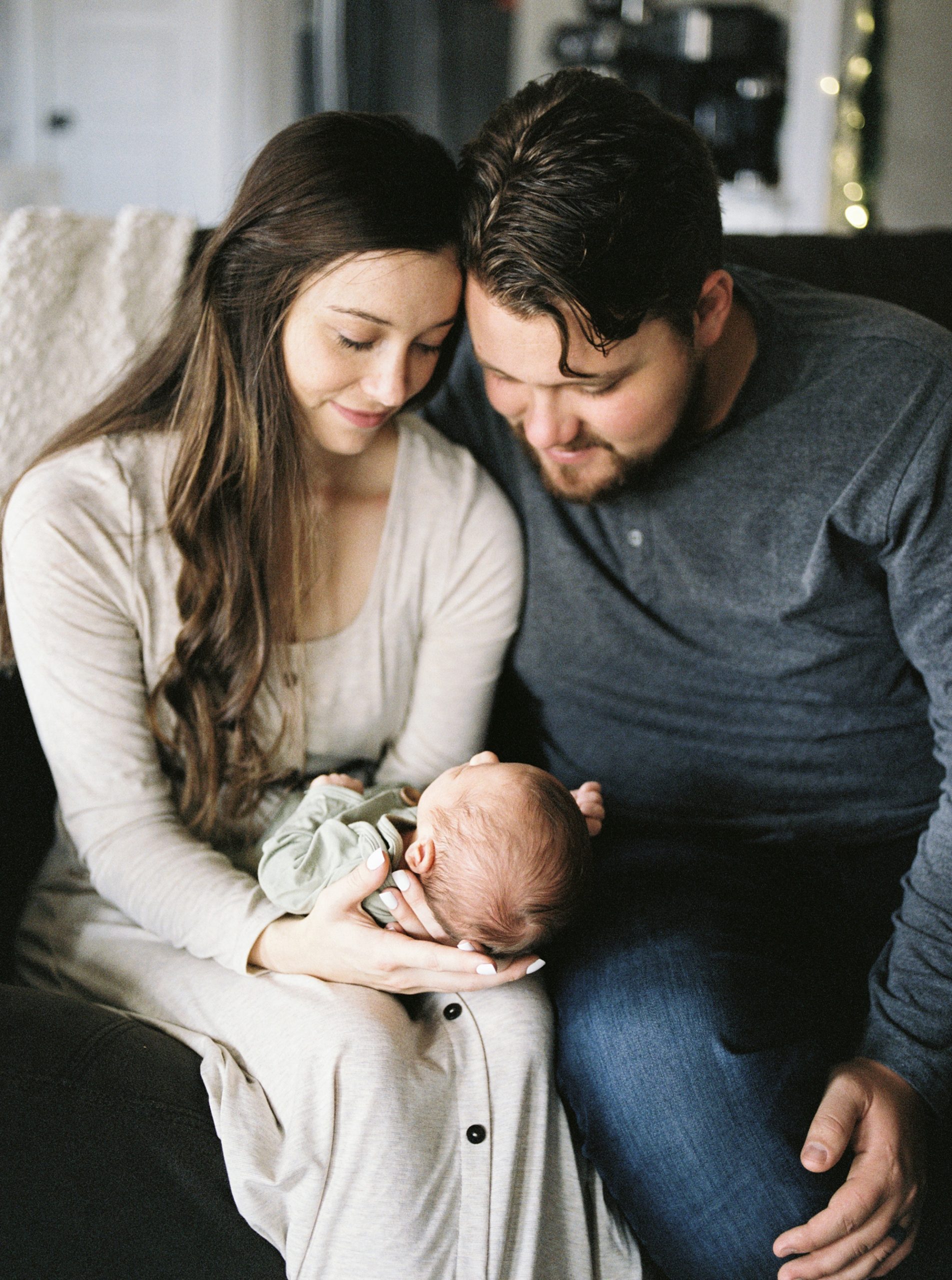 new parents look at baby boy during lifestyle photos at home