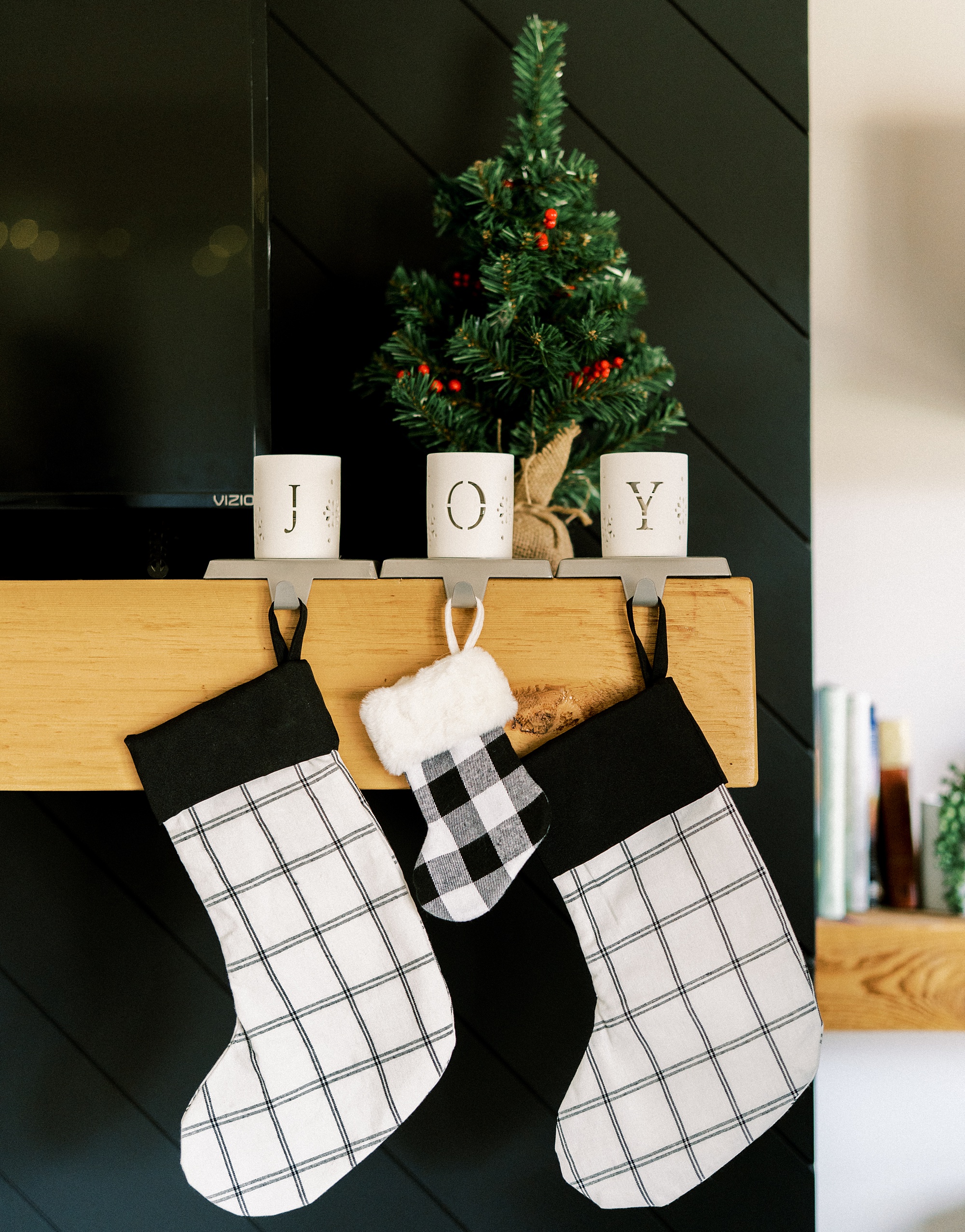 three stockings hang on mantle during lifestyle newborn photos at home