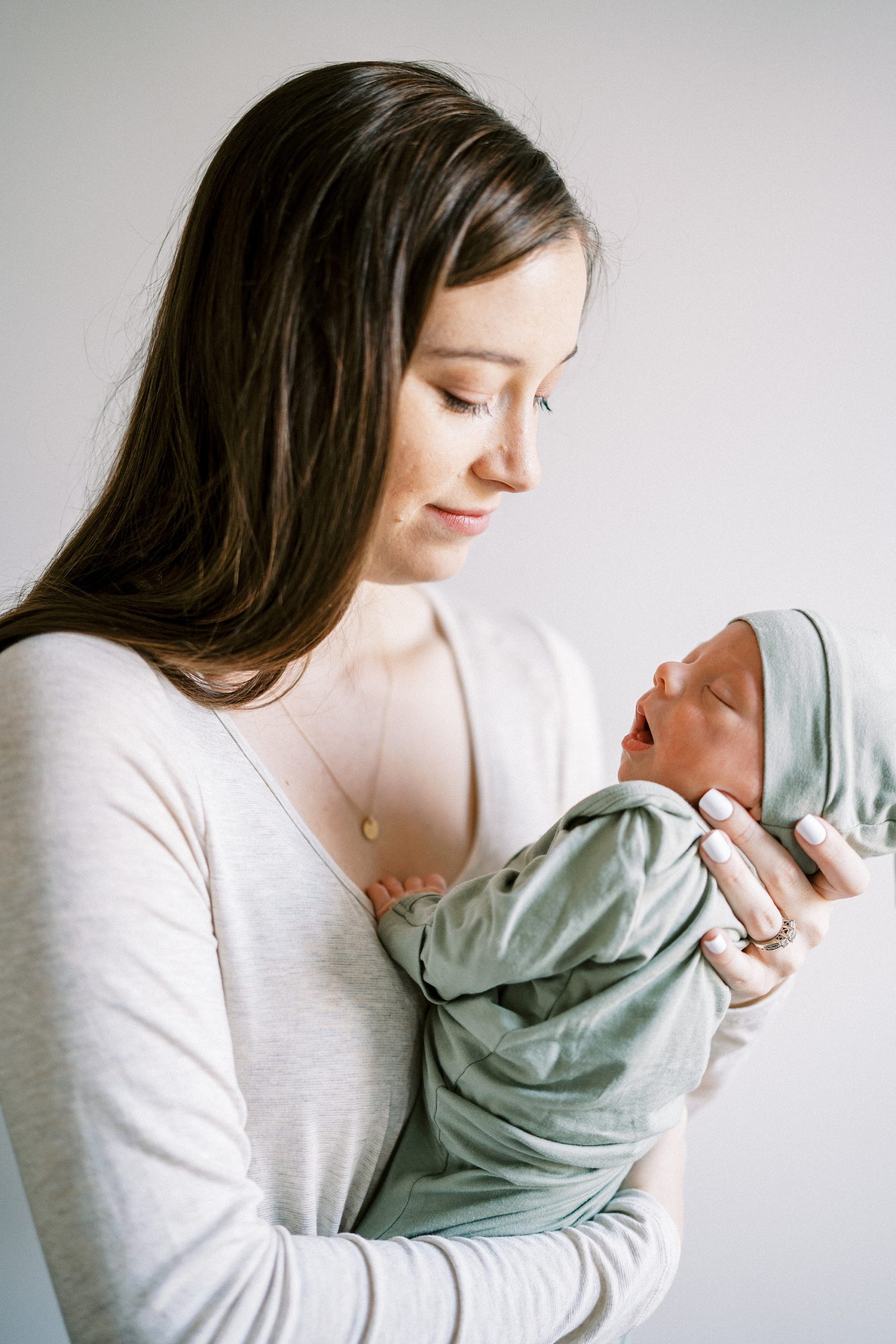 mom holds baby boy during In Home Lifestyle Newborn photos