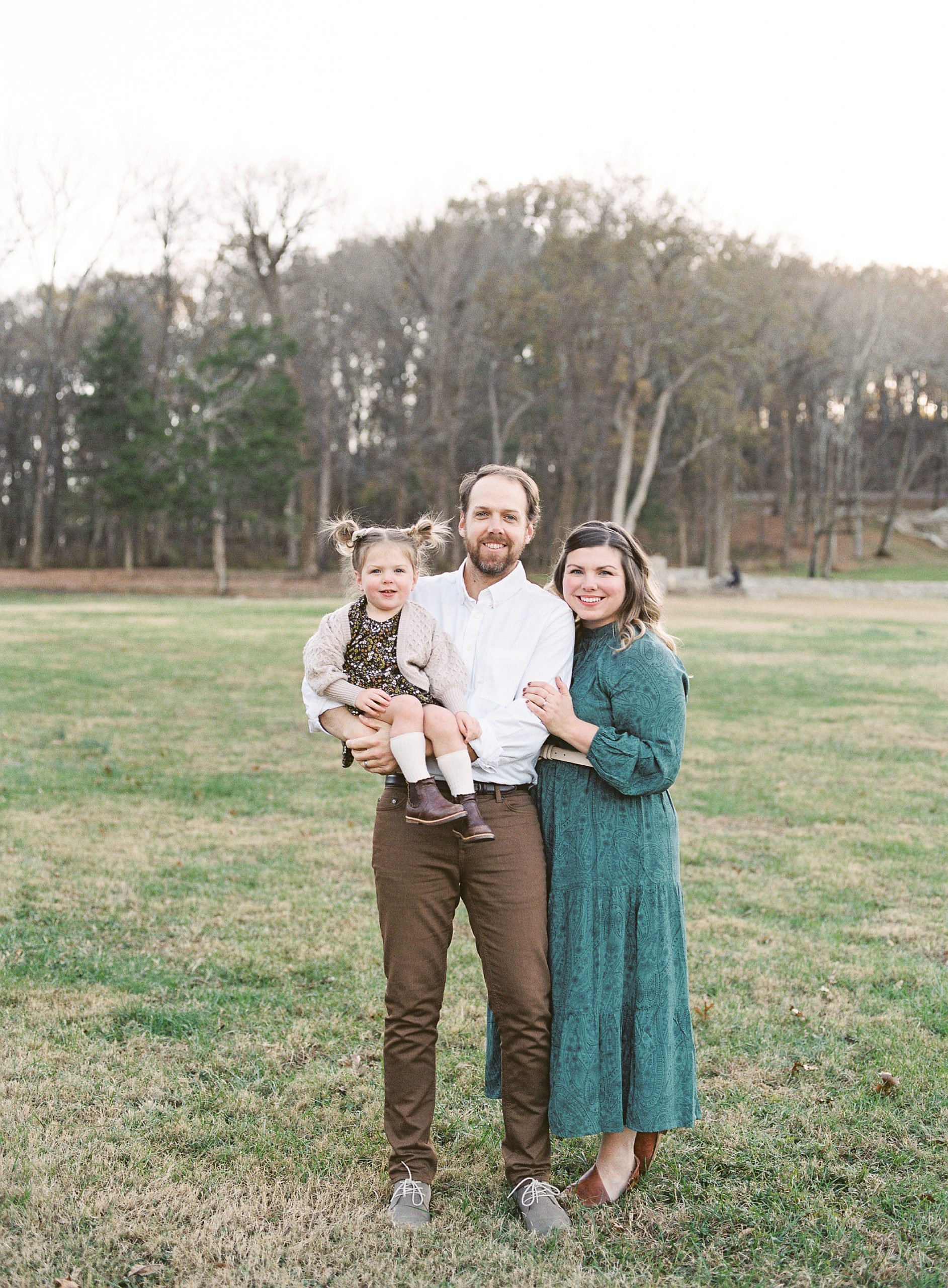 family of three poses together during Nashville outdoor family session
