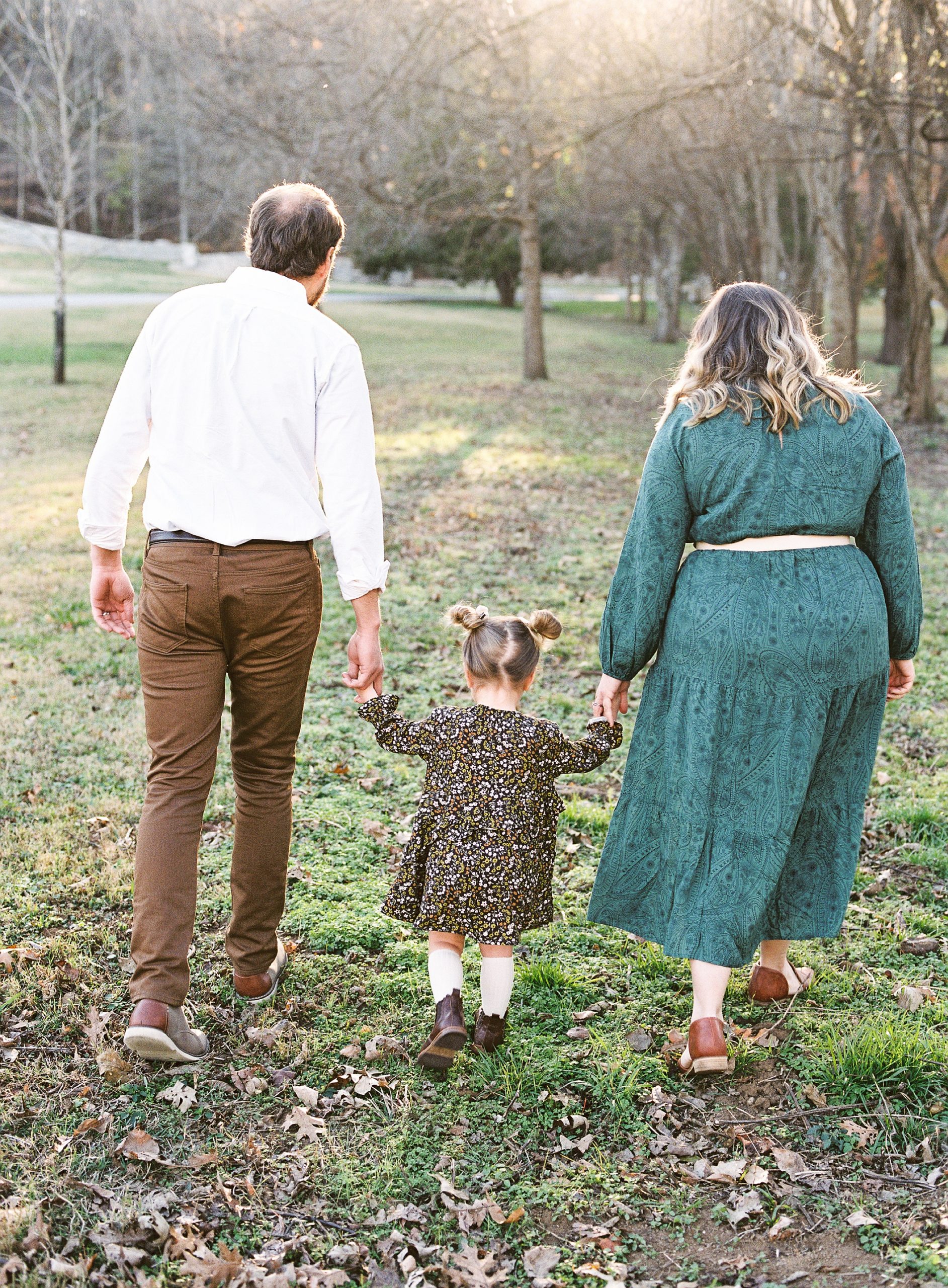 parents hold toddler's hands during Nashville family photos