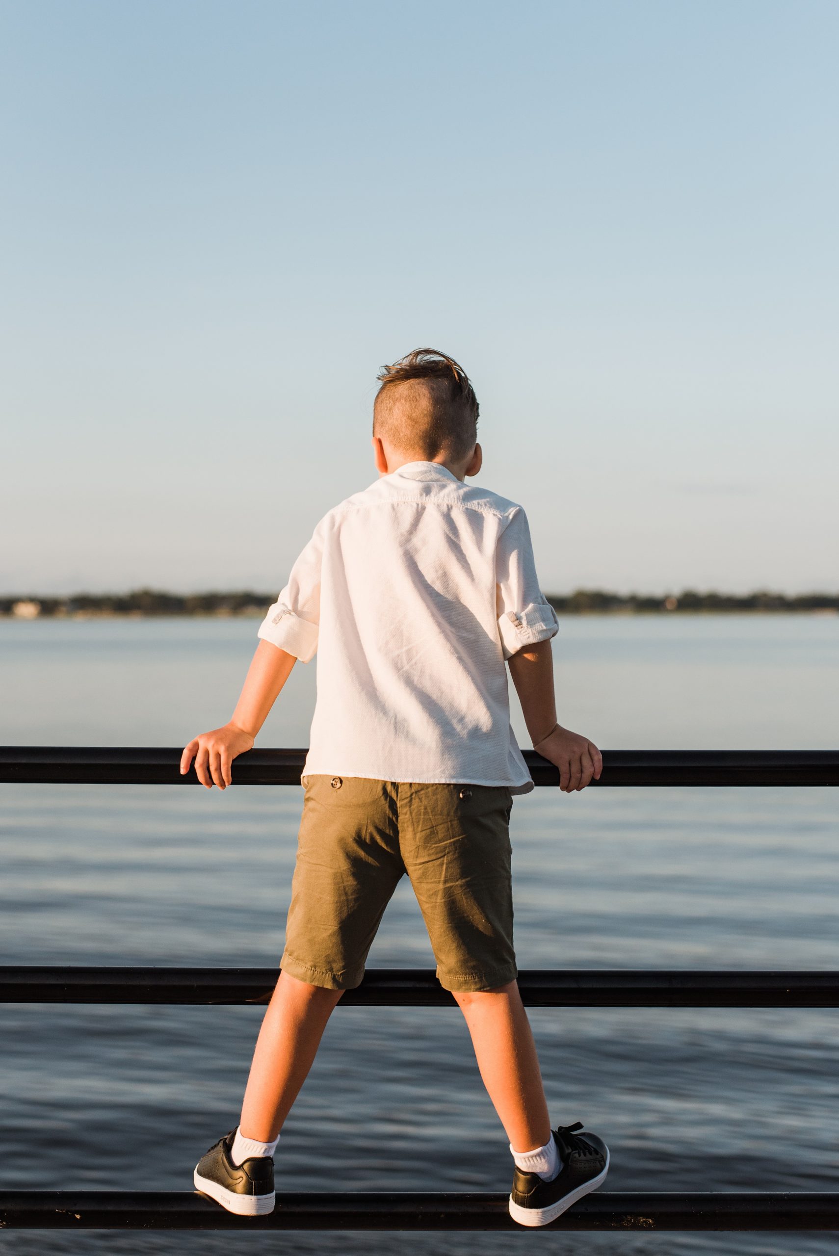 toddler looks over railing along Charleston waterfront