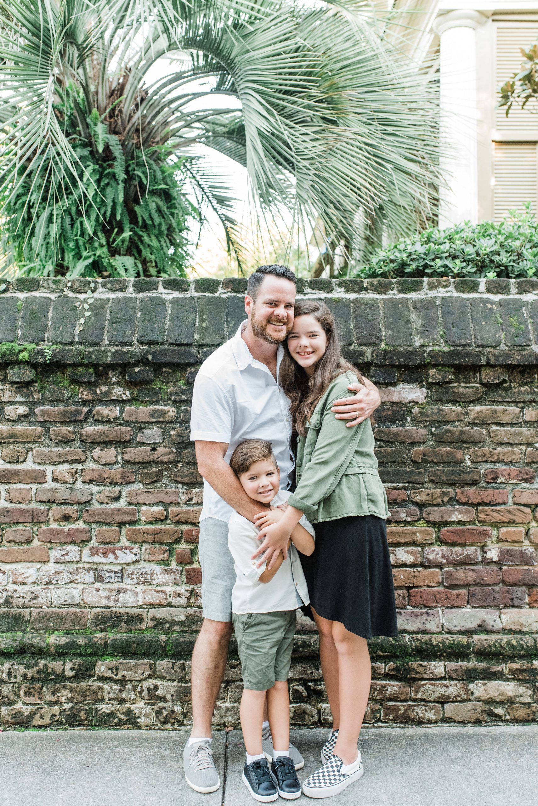 family poses by brick wall in South Carolina