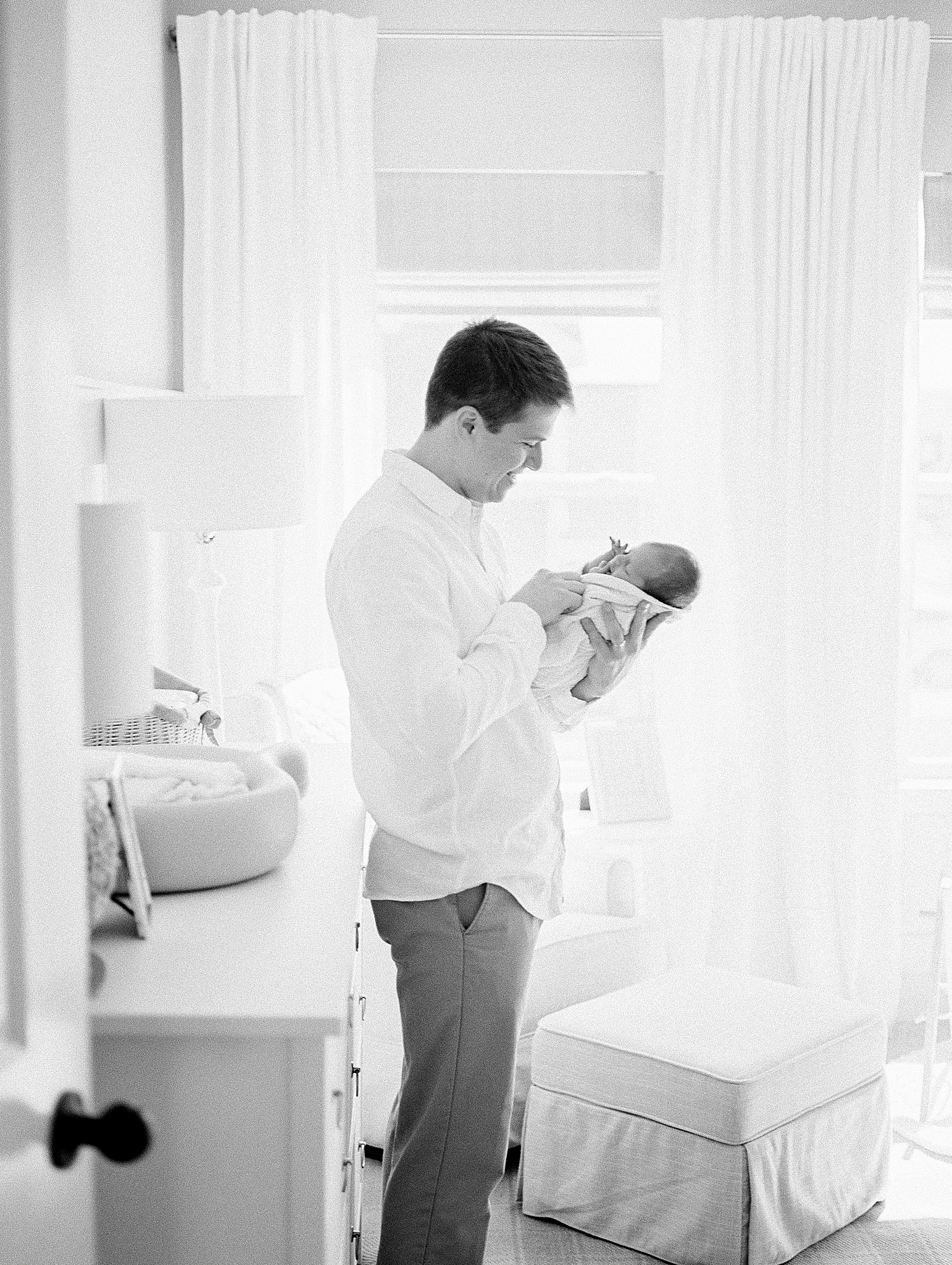dad holds son in nursery during at home newborn portraits