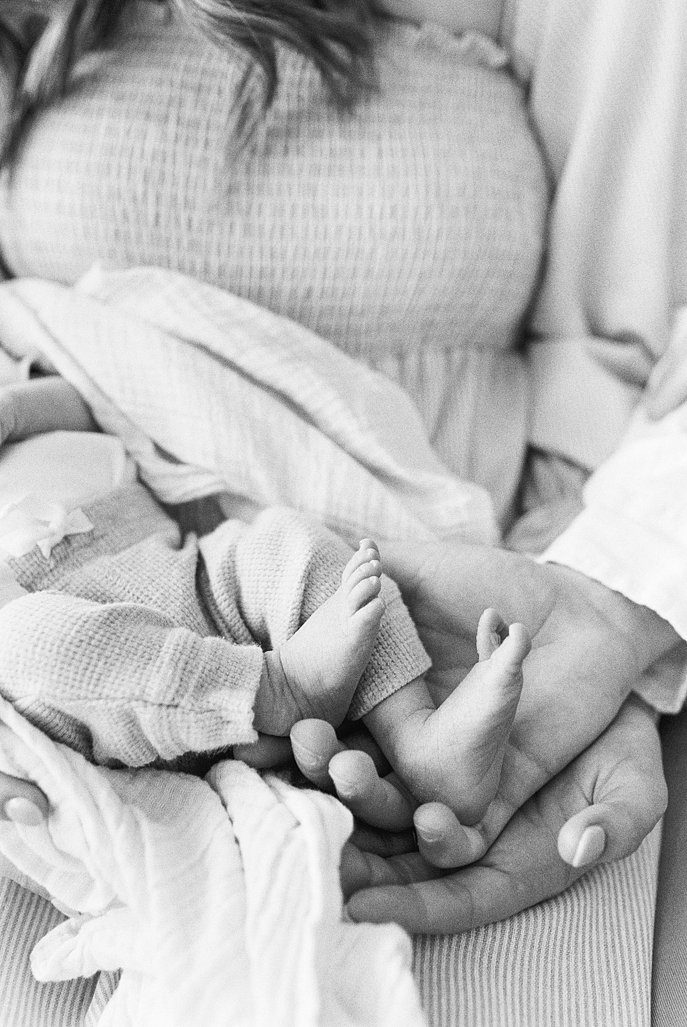 mom holds son's toes during newborn photos in TN