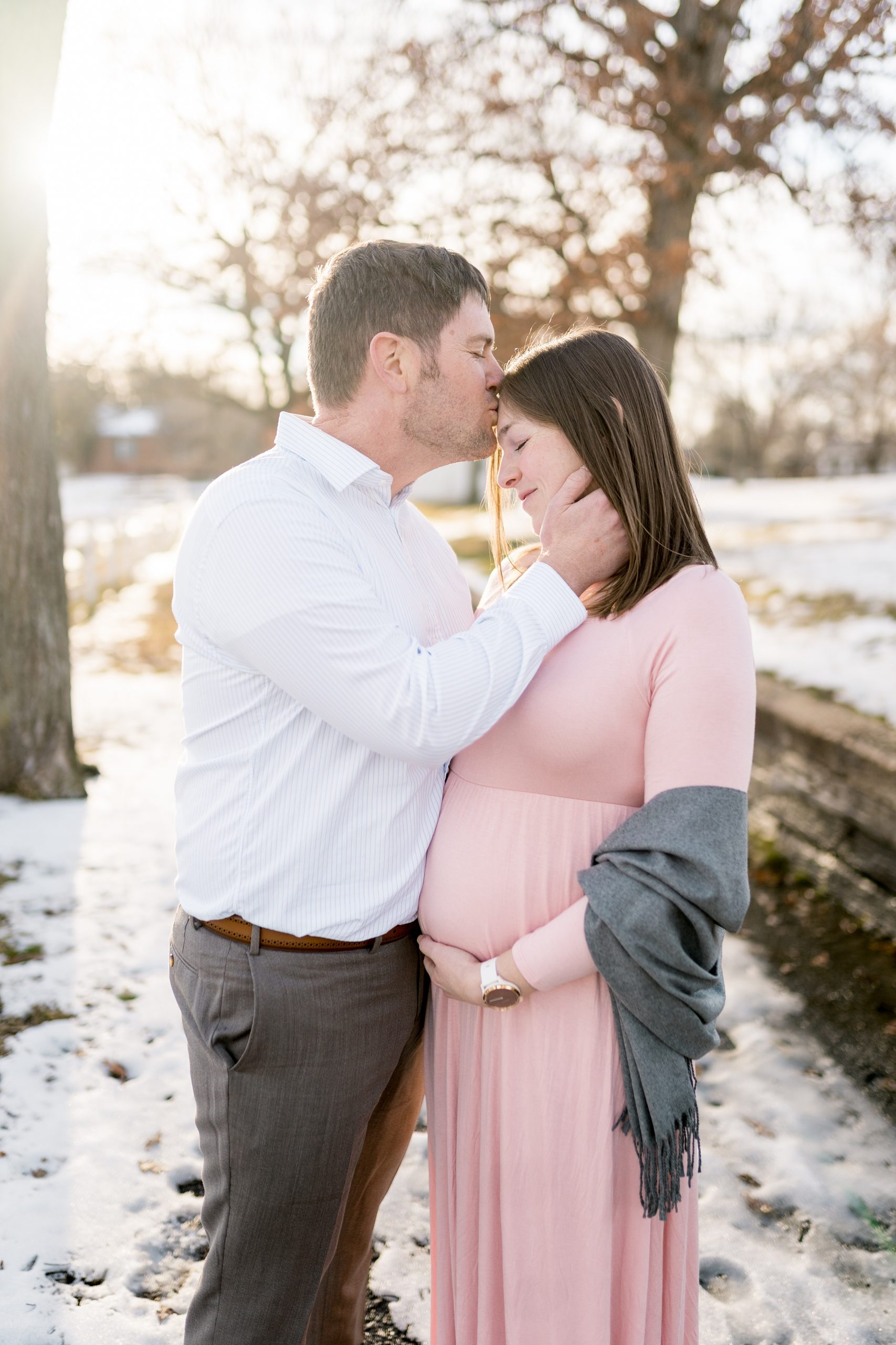husband kisses wife's forehead during Nashville maternity photos