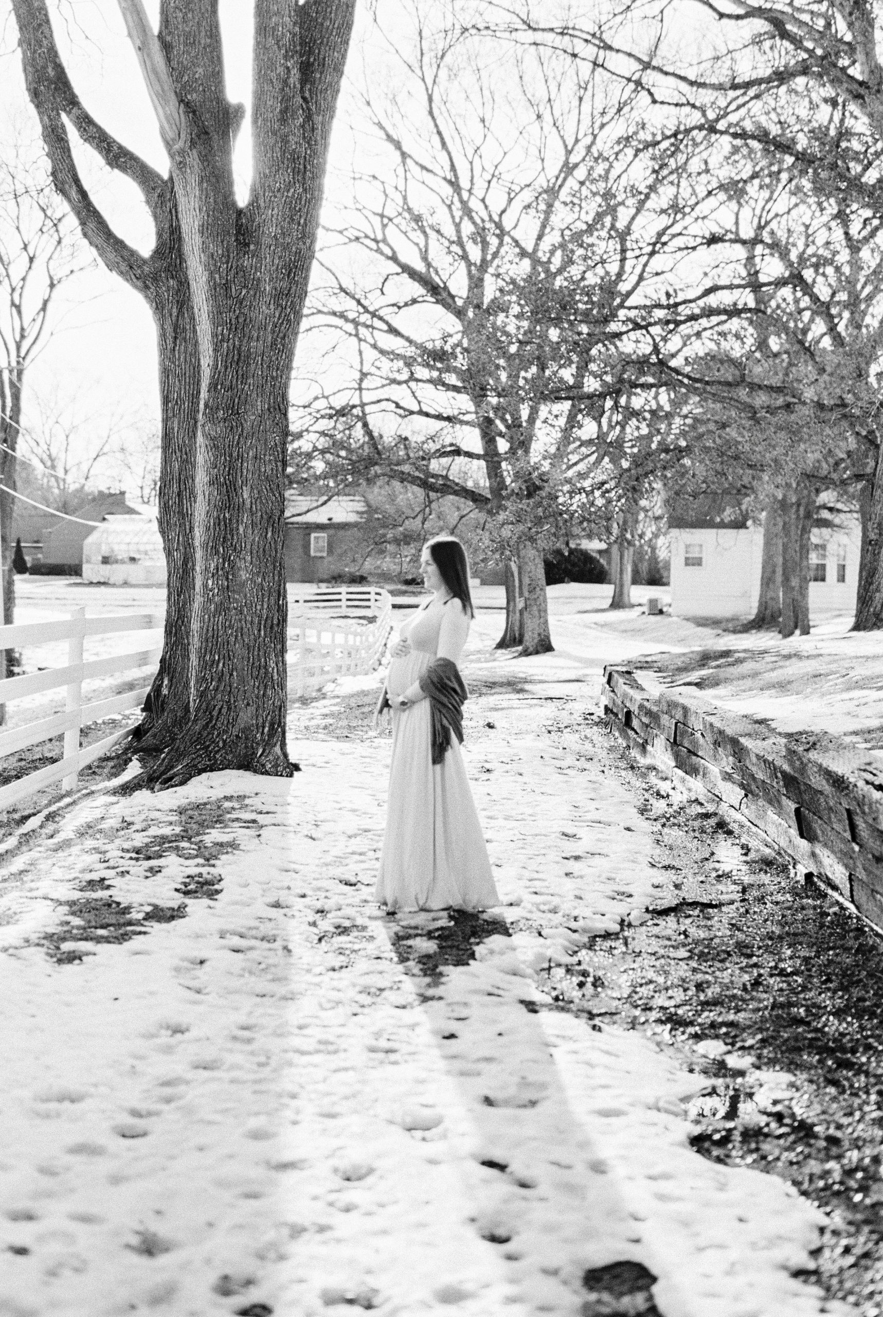 mom poses on snow covered path during Nashville maternity photos