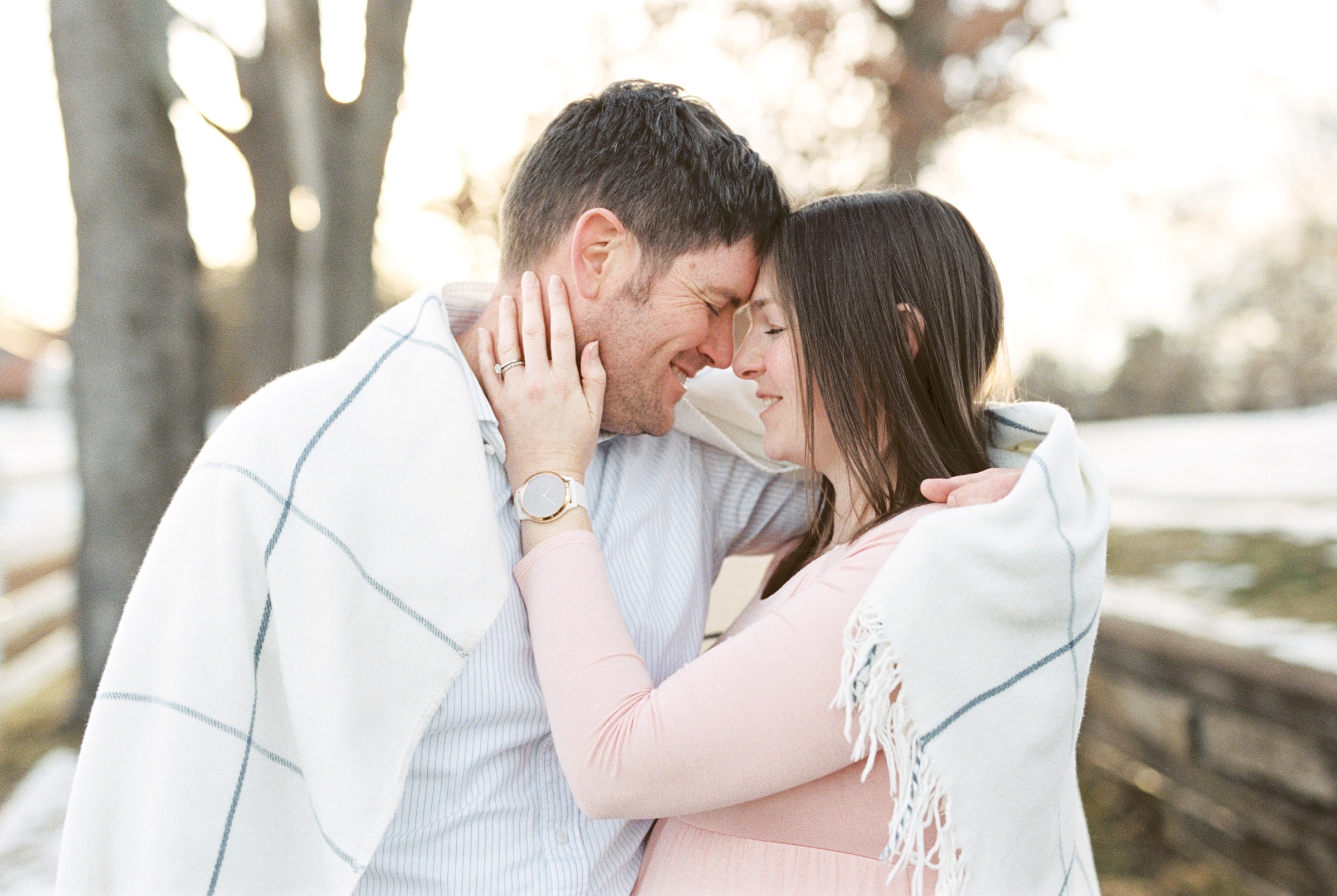 Nashville maternity photographer captures couple hugging in blanket during maternity photos
