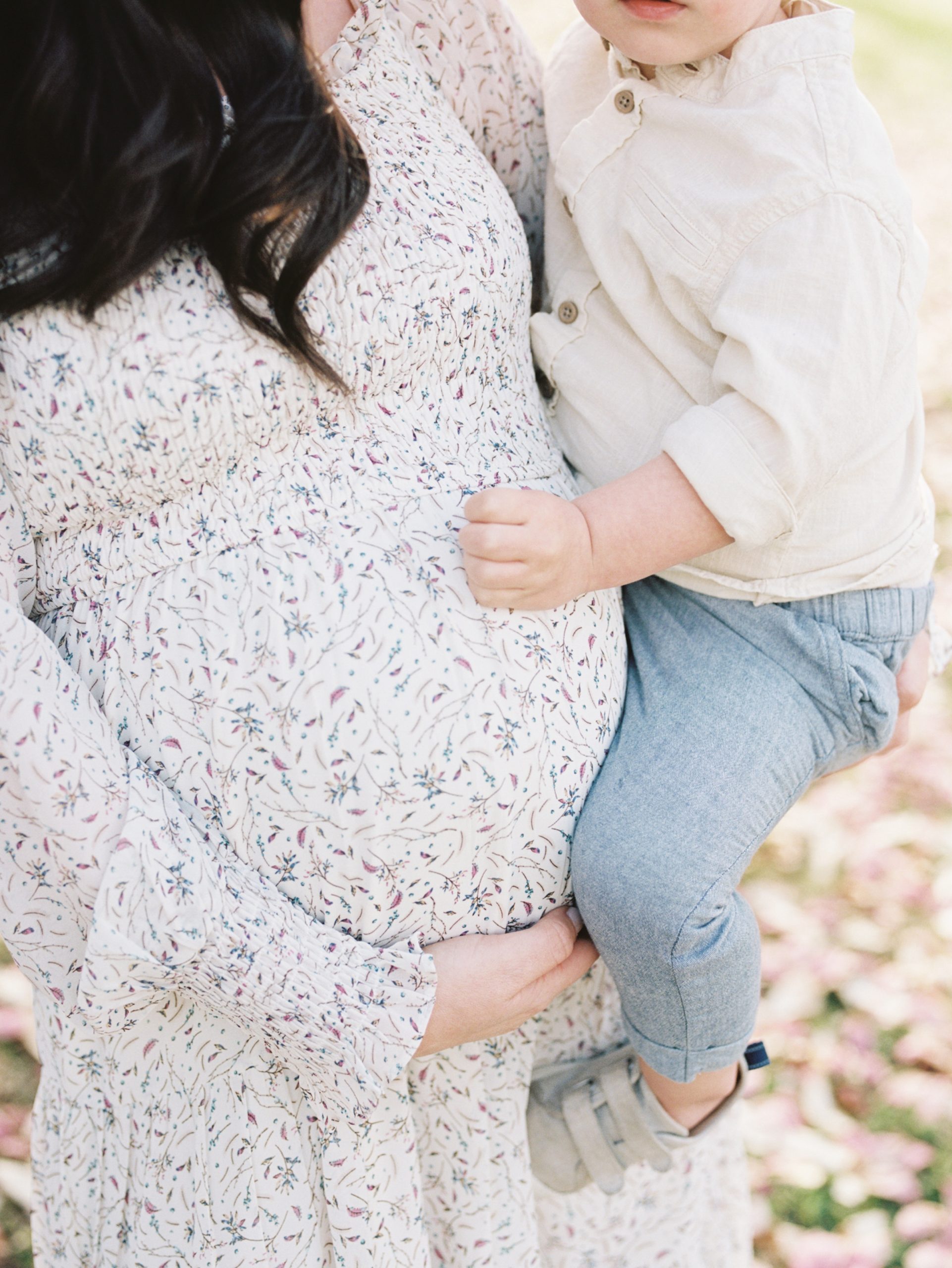 mom holds toddler son and belly during Ellington Agricultural Center maternity photos