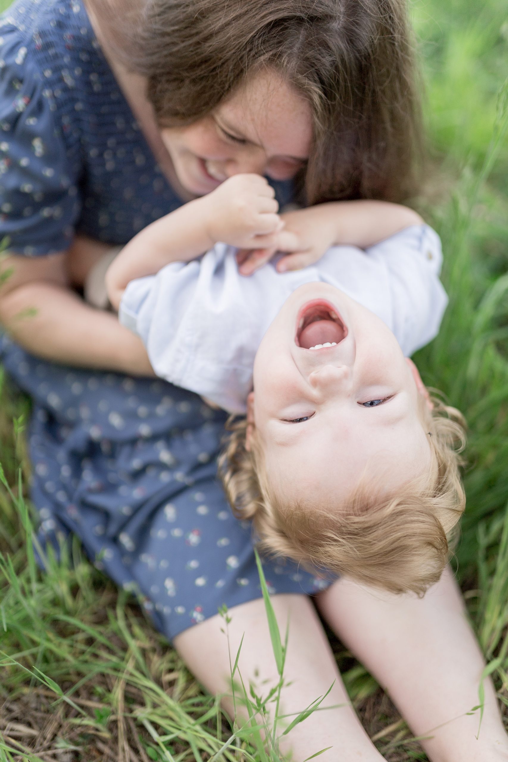 mom tickles toddler boy as he giggles during Murfreesboro Family Portraits