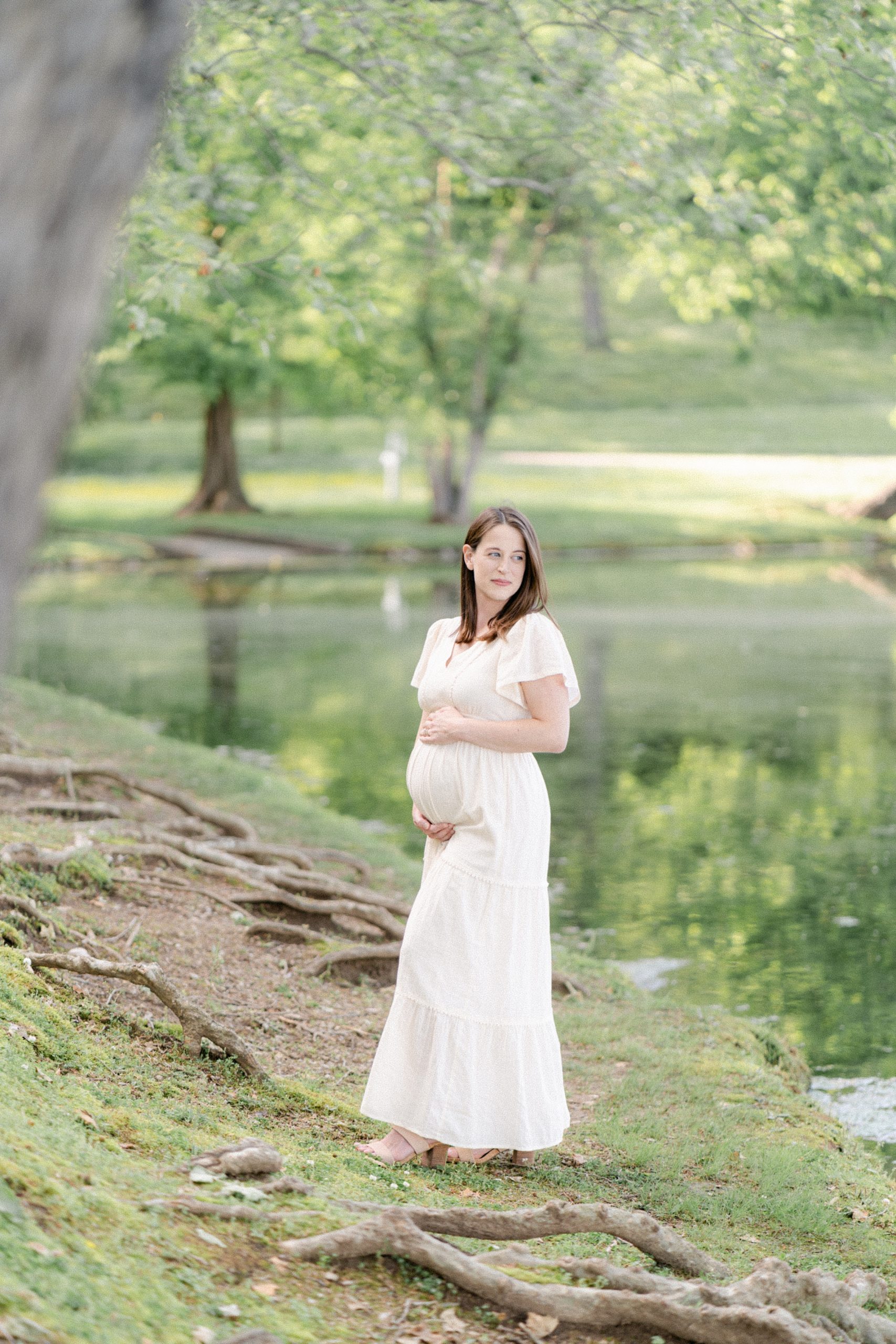 mama holds baby belly by pond for Nashville TN Maternity portraits