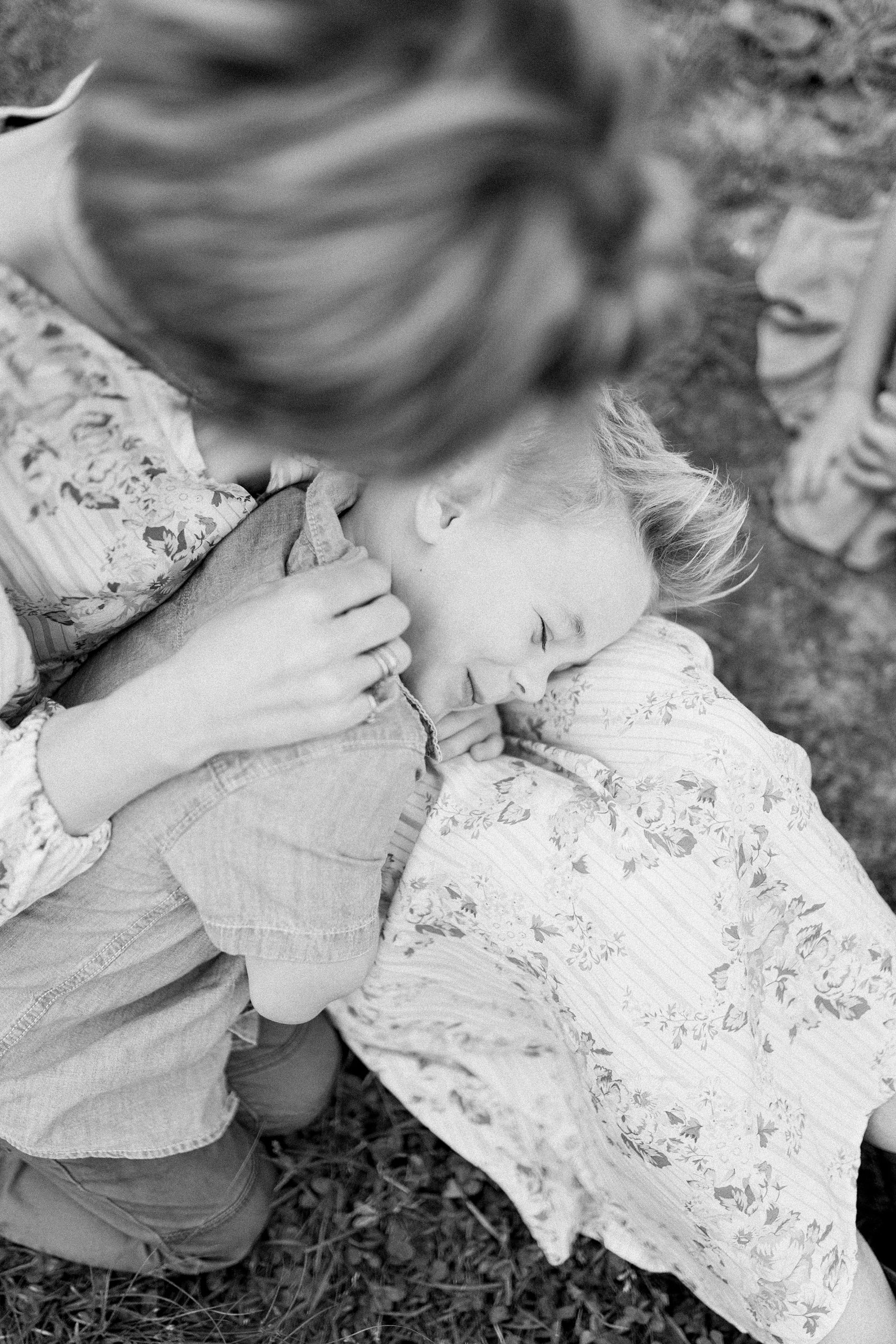 black and white photo of boy laying across his mom's lap during Brentwood Family Mini Session