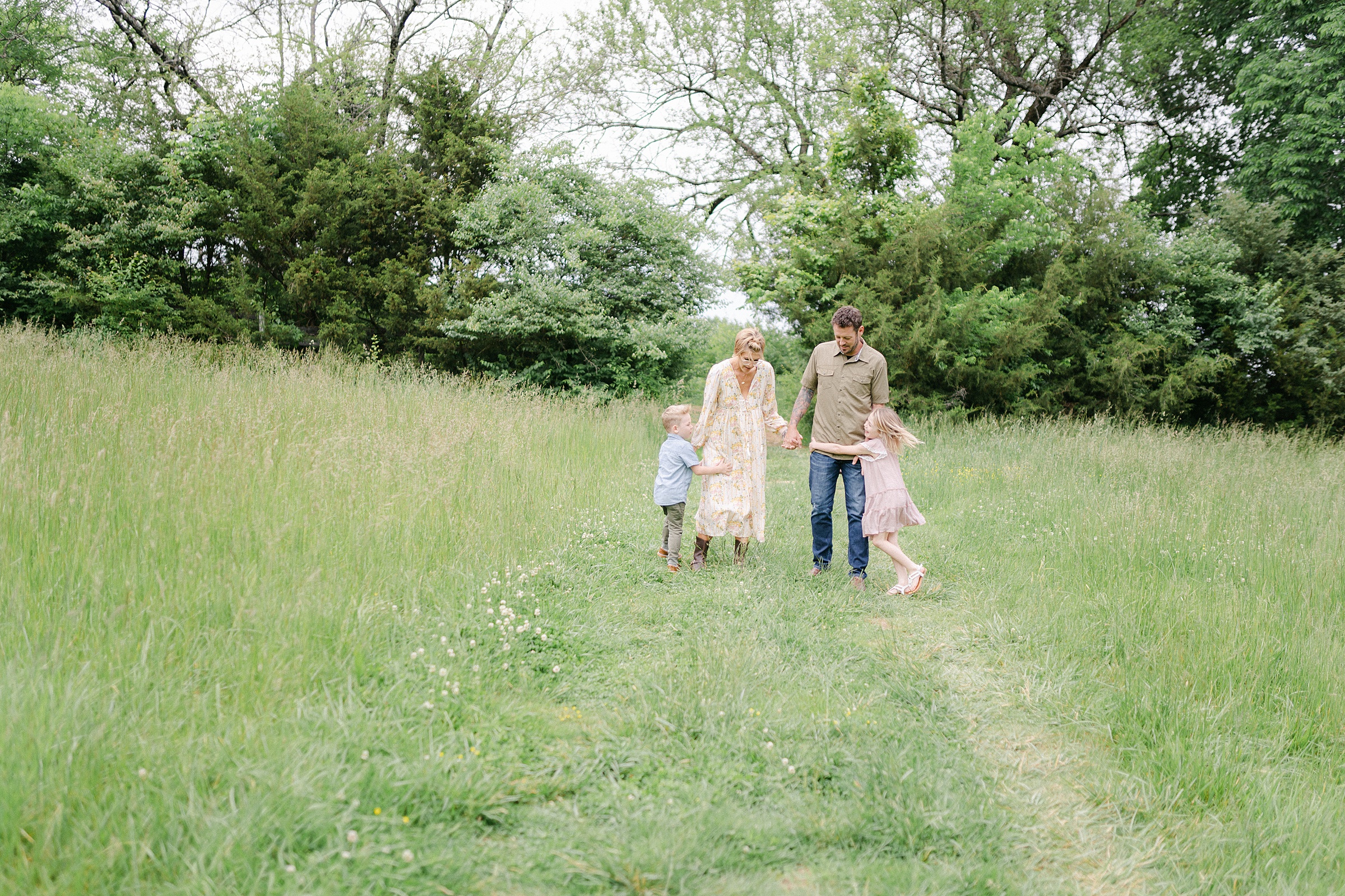 family walks in field for Brentwood family photos
