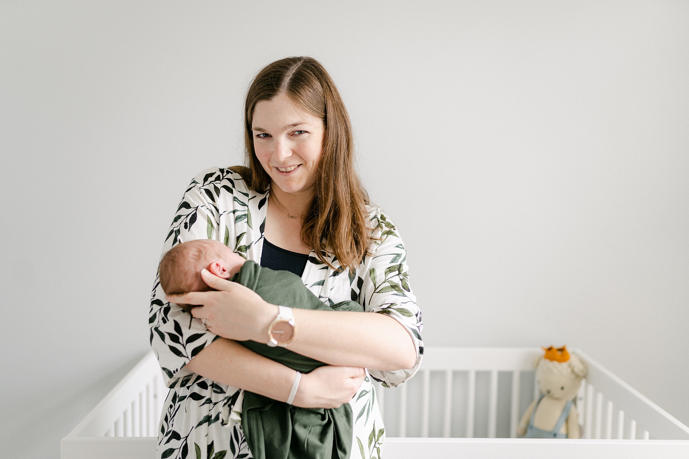Mom holds newborn son in backlighting during TN In-home Session