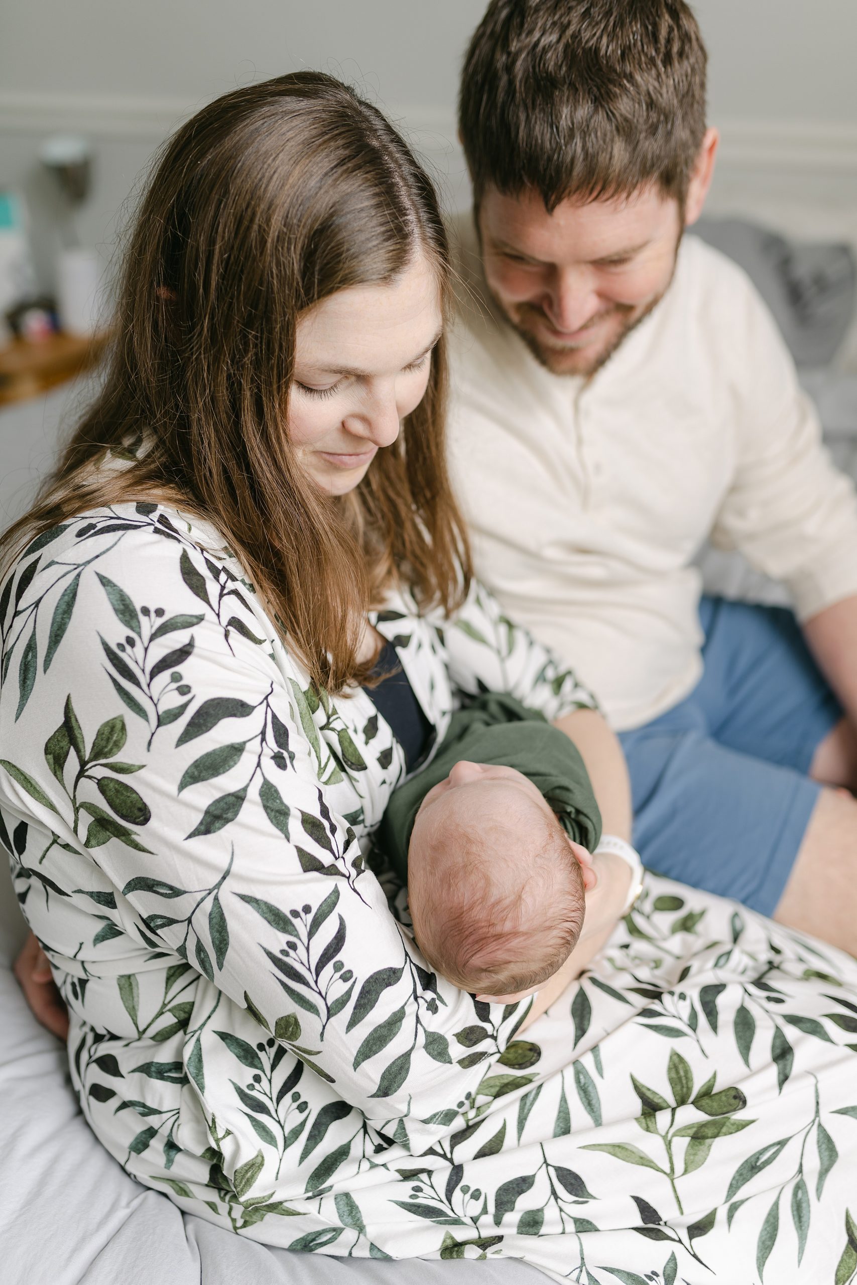 Mom holds newborn son sitting next to dad during family session