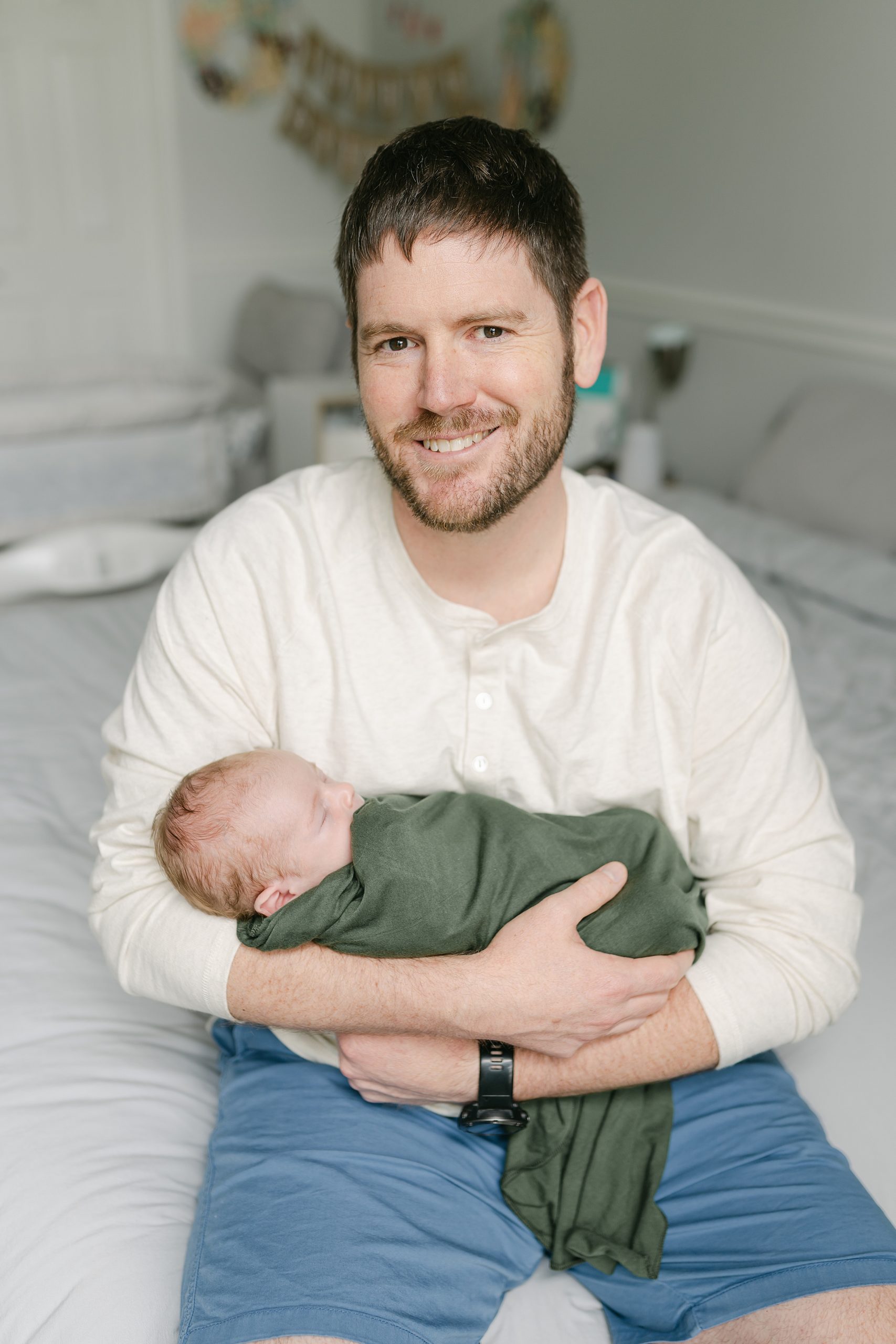 dad holds son proudly in lifestyle newborn session