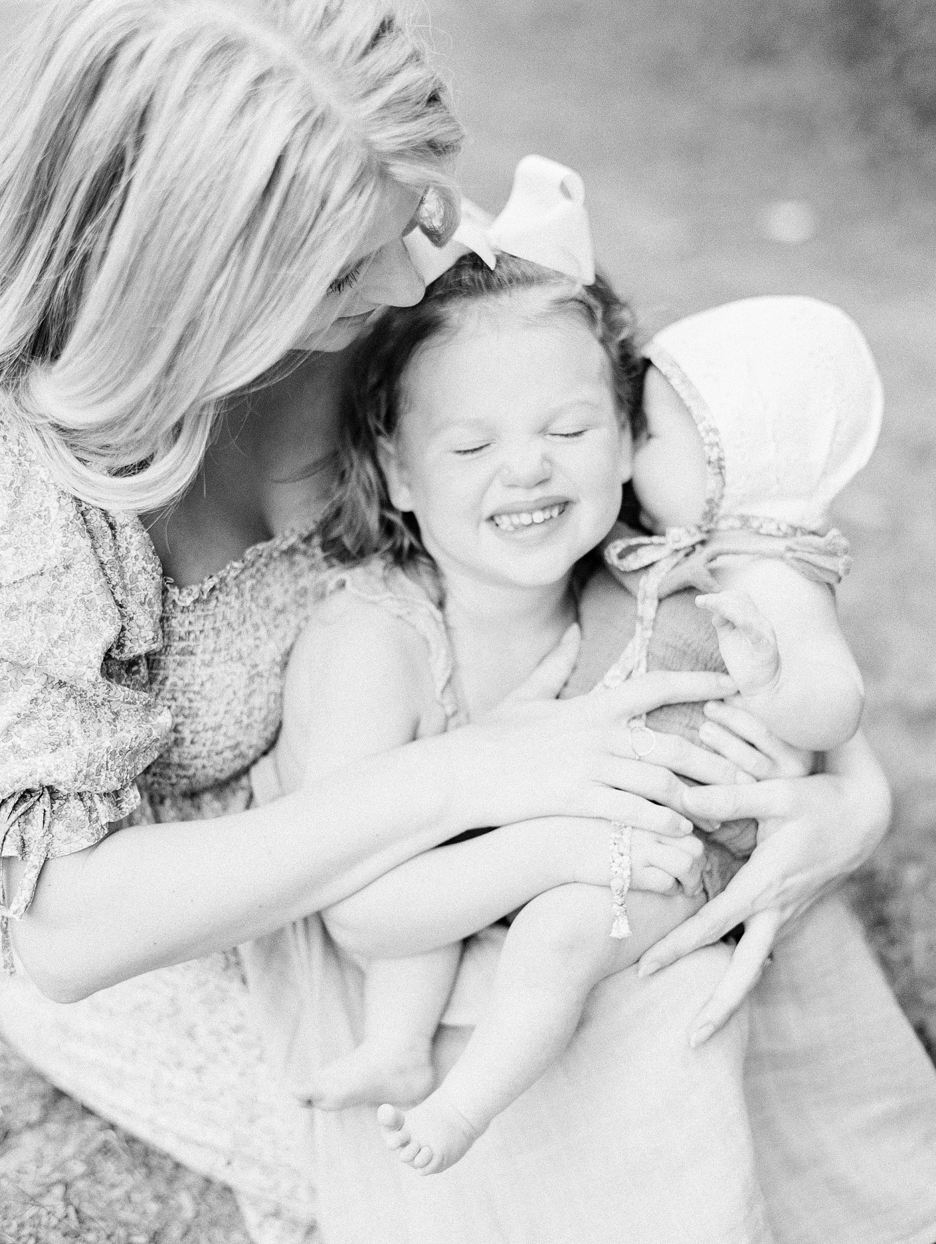 mom holds daughter close in black and white photo
