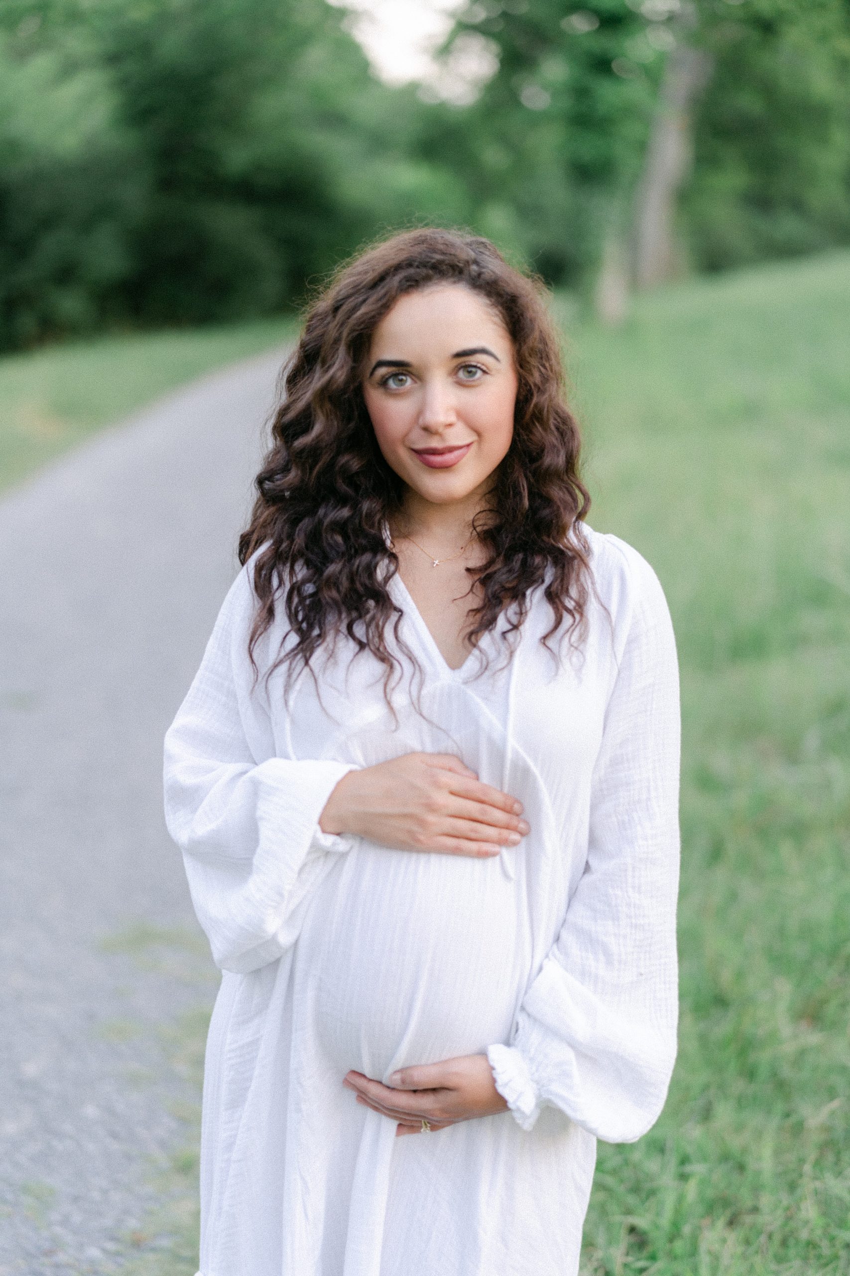 Pregnant woman holds baby bump during Maternity session