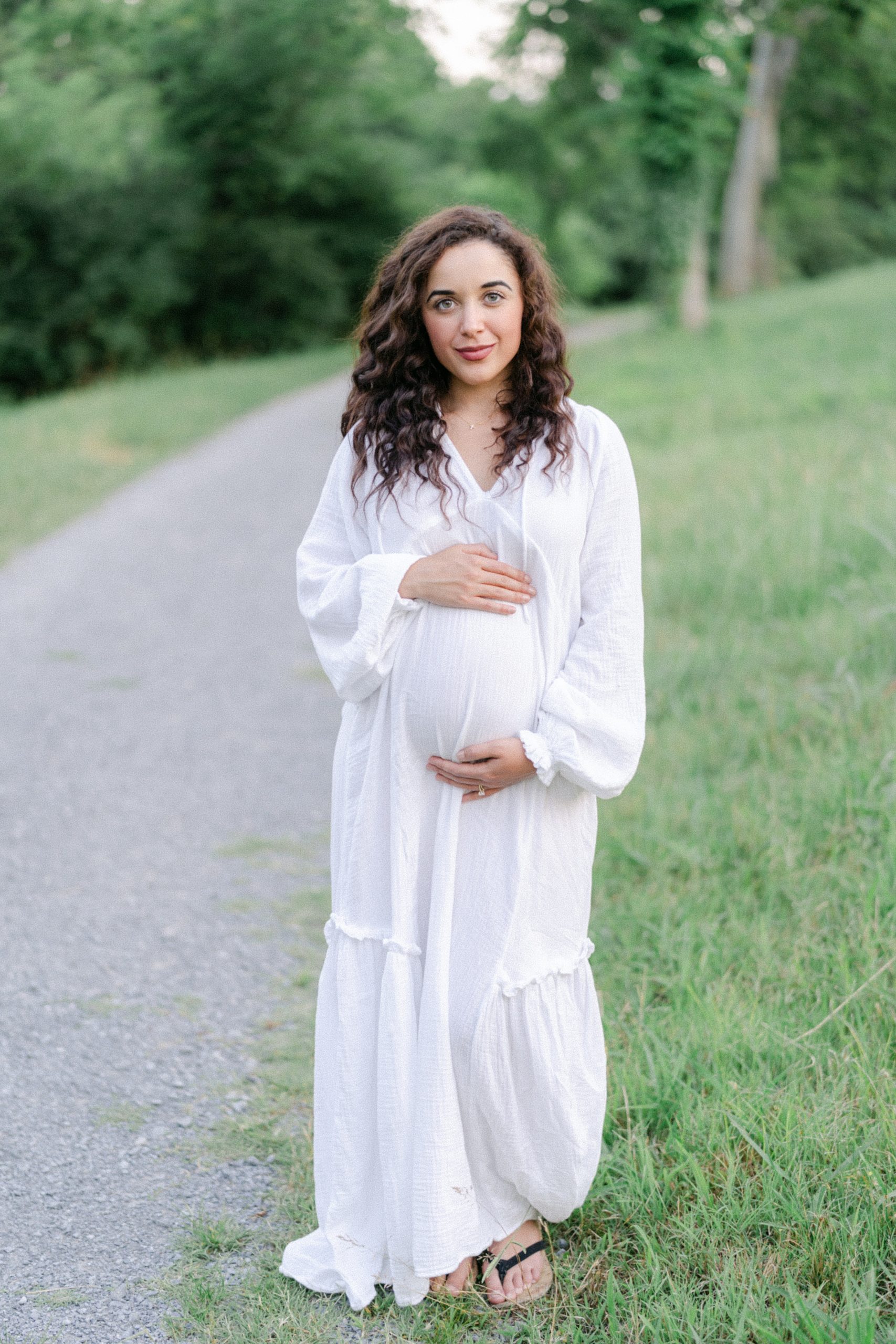 Pregnant woman holds baby bump during Maternity session