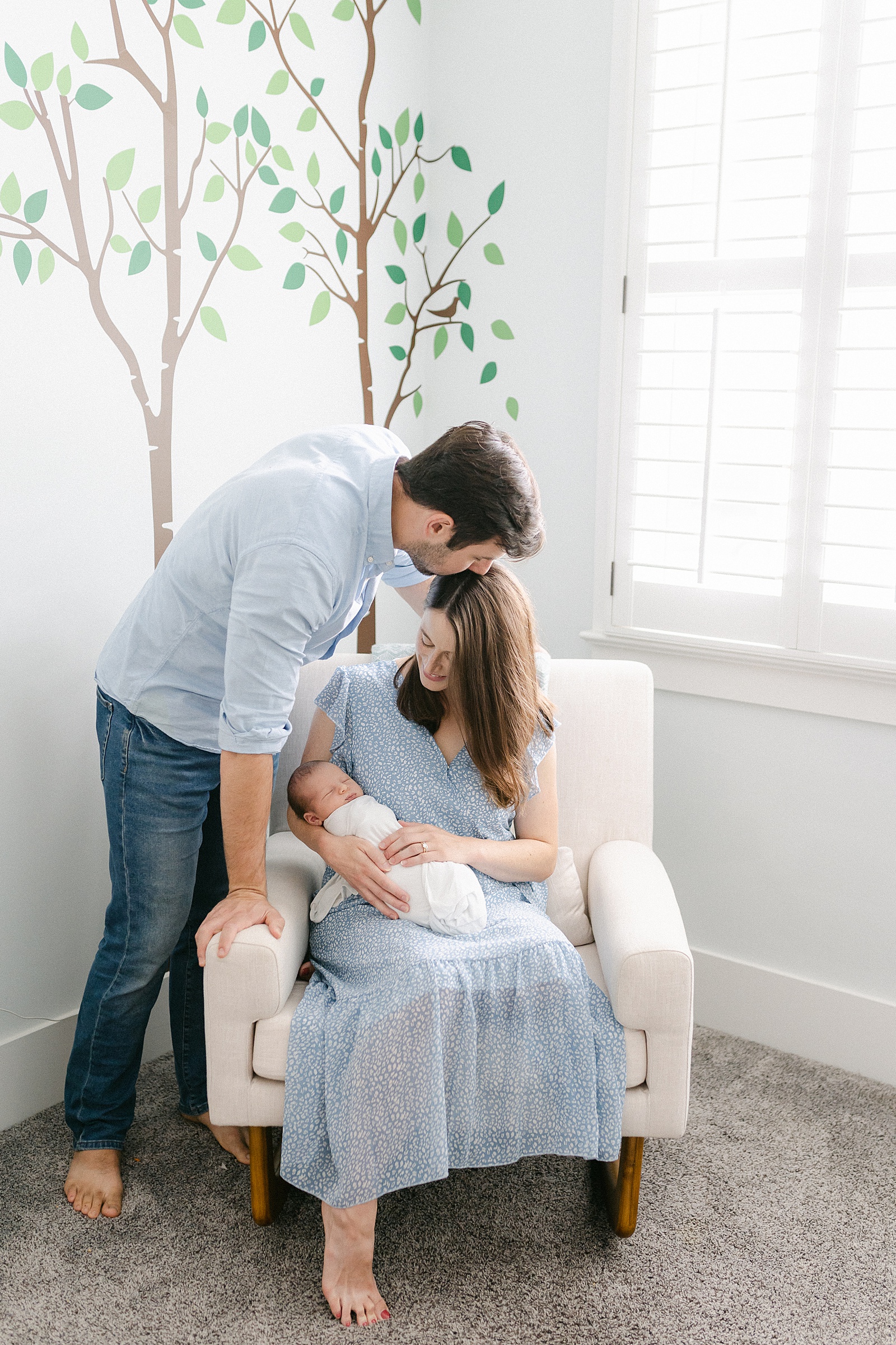 mom holds son in nursery while dad looks over them during in-home Nashville Lifestyle Newborn Session