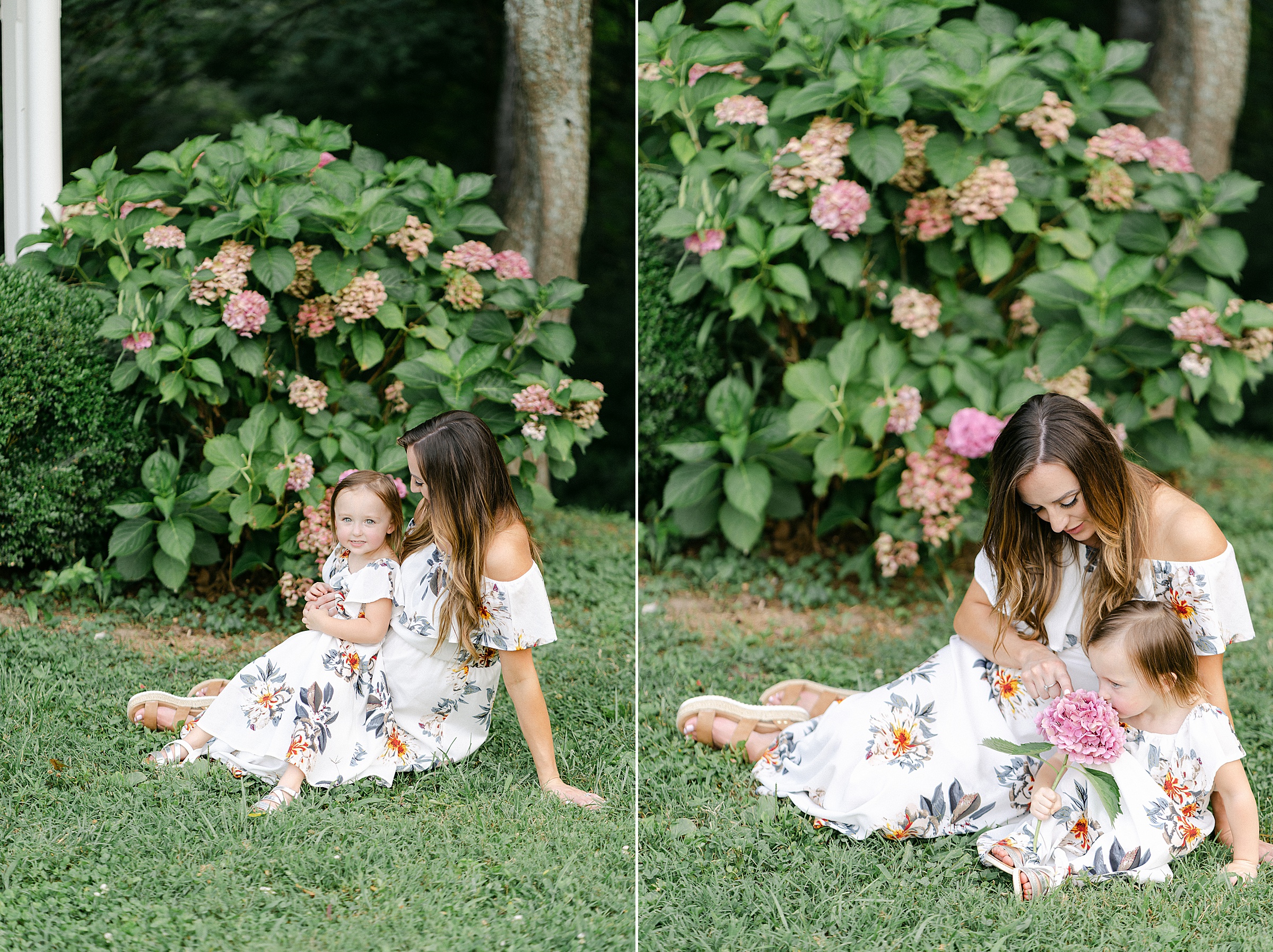 mom and little girl sit by beautiful flower bushes