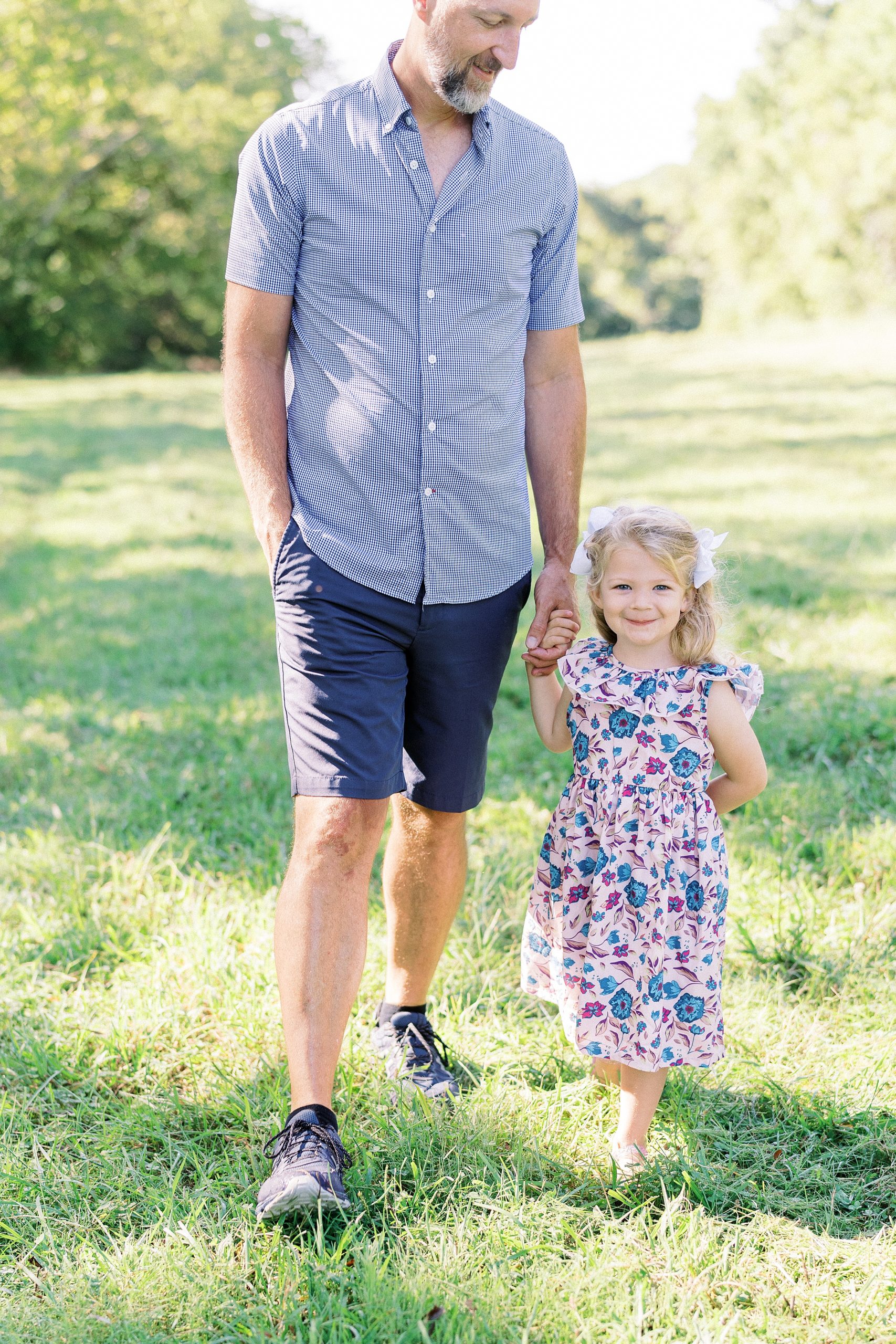 dad holds daughter's hand during family photos