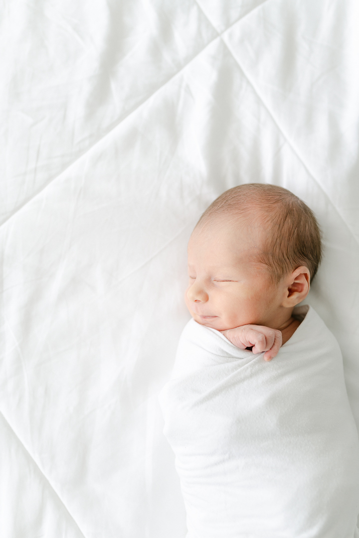 newborn on white blanket - 5 Tips for Taking Photos of Your Baby at home