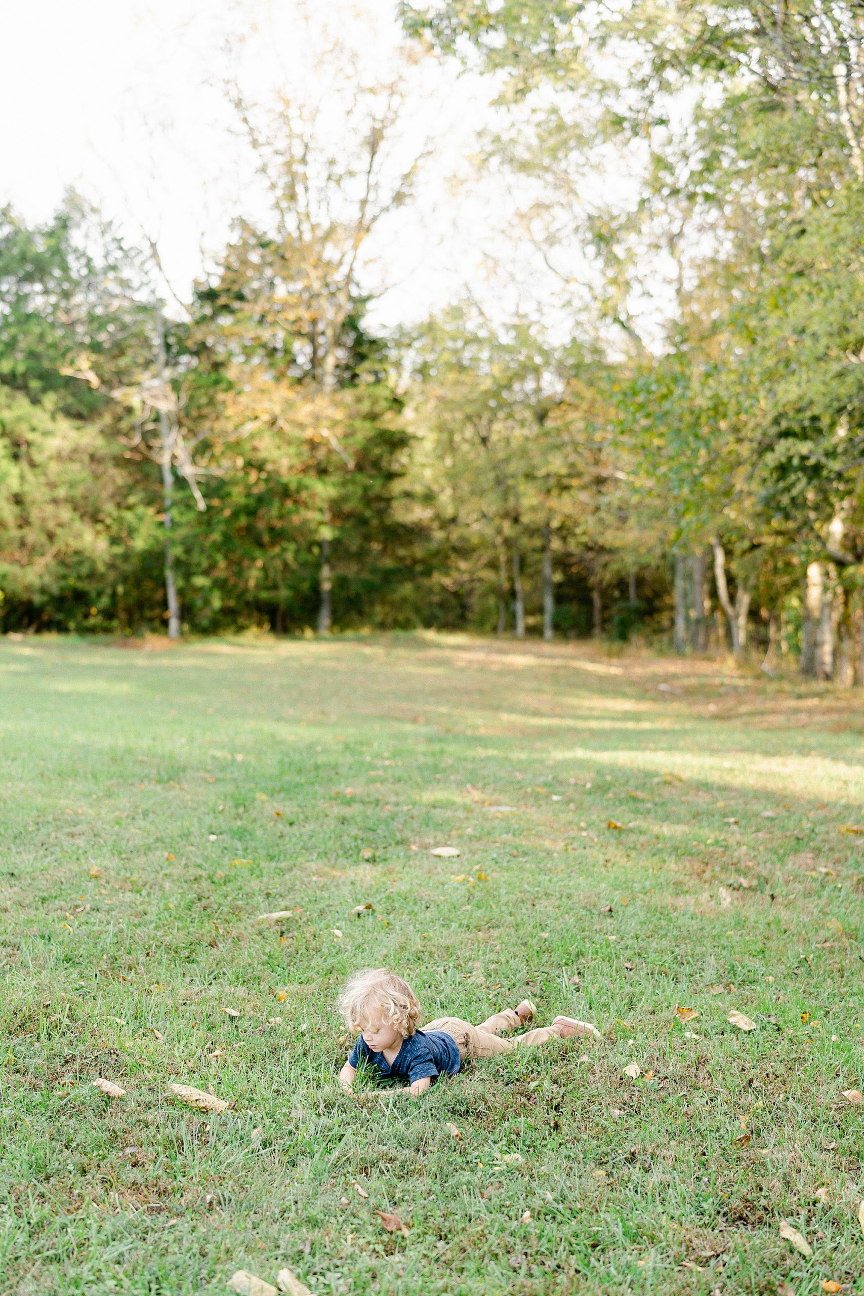 little boy plays in grass
