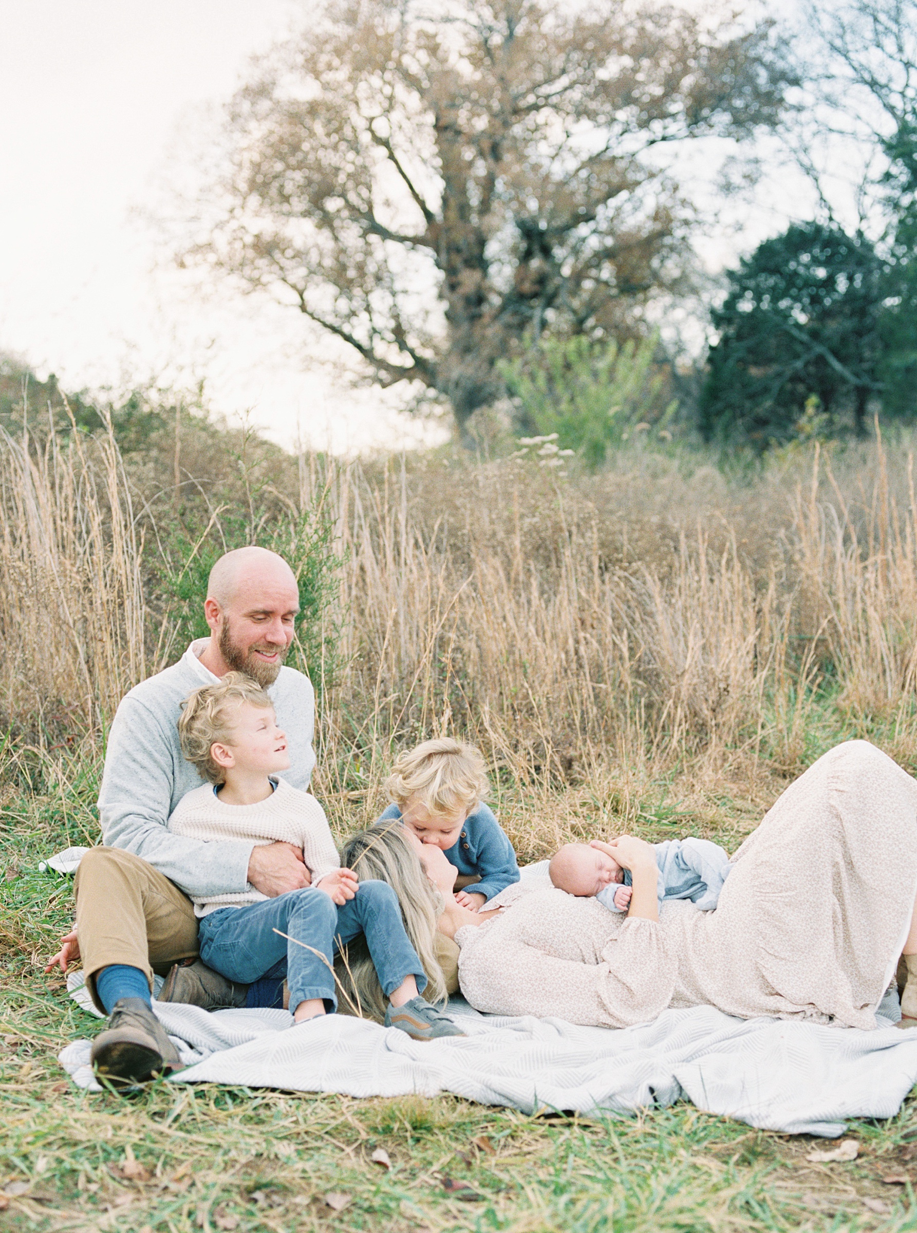 Brentwood outdoor newborn and family Session as family of 5 lays in grass