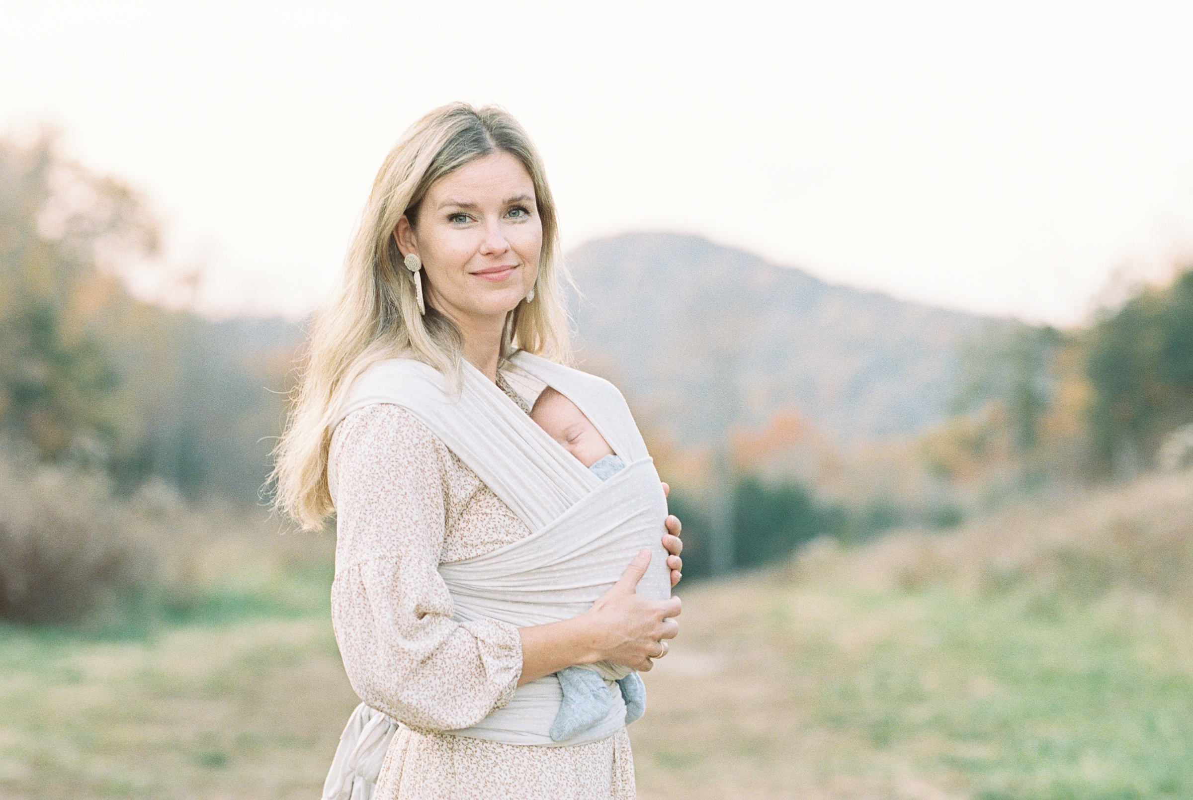 mom holding newborn baby boy with mountain in the background