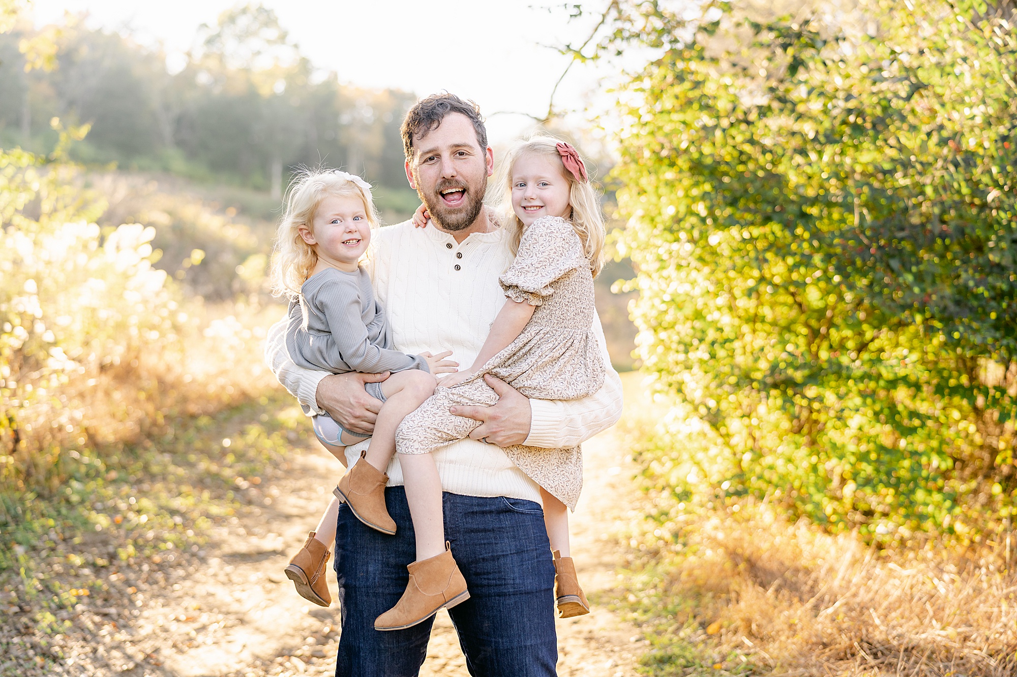 dad holds up his two girls during Brentwood Tennessee Family Session