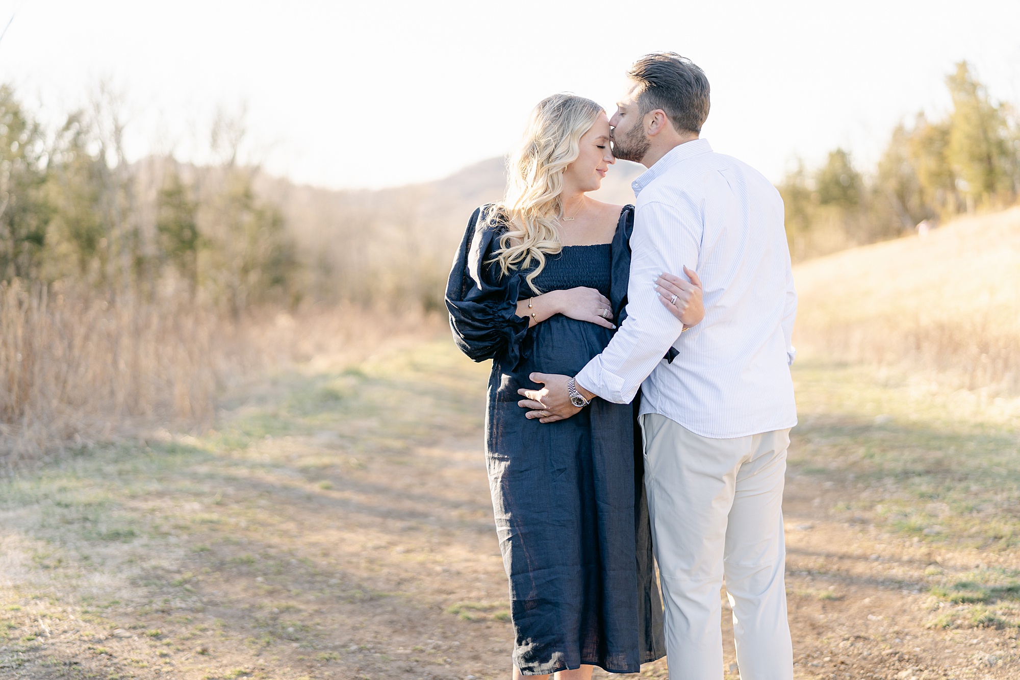 man kisses wife's forehead during Tennessee Maternity Portraits